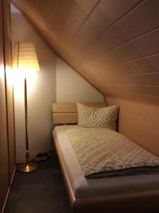 a small bedroom with a bed and a lamp at Apartment Jane in Bad Schonborn