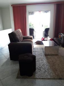 a living room with a chair and a ottoman at Casa Família Sena in Piranhas