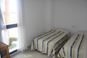 2 Betten in einem Zimmer mit Fenster in der Unterkunft Apartment close to the Beach in Denia