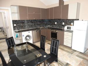 a kitchen with a black table and a white refrigerator at Apartments DIEM in Samokov
