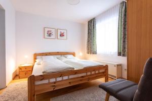 1 dormitorio con cama de madera y ventana en Haus am Stein, en Oetz