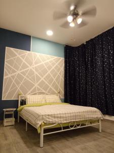 sypialnia z łóżkiem i wentylatorem sufitowym w obiekcie ICOLOR HOME & STAY CH4 w mieście Tanah Rata