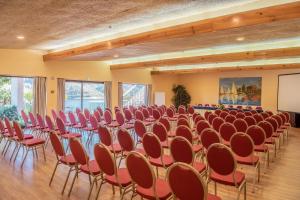 a large room with rows of chairs and a screen at Lago Azul Eco Hotel in Ferreira do Zêzere