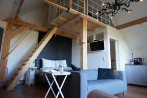 a living room with a blue couch and a staircase at Casaprisco in Putten