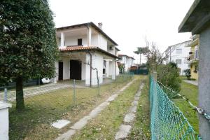 una valla delante de una casa blanca en Villetta LINDA 8, en Lido delle Nazioni
