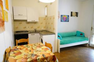 Una cocina con una mesa y un sofá en una habitación. en Villetta LINDA 8, en Lido delle Nazioni