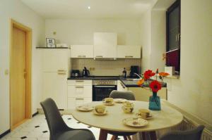 a kitchen with a table and chairs and a kitchen with a table and a table at Ferienwohnung am Rathaus in Heidenau