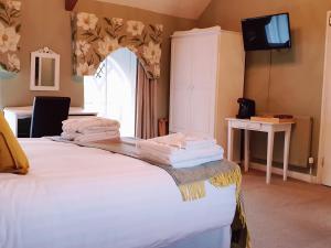 um quarto com uma cama com toalhas brancas em Orles Barn Guest House em Ross on Wye