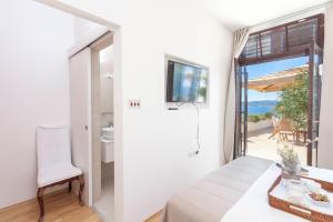 a bedroom with a view of the ocean from a balcony at Guesthouse Mate Ledic in Brela