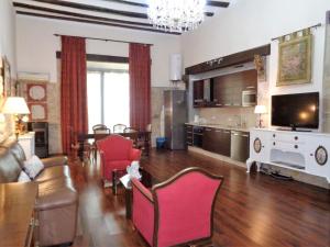 a living room with a couch and chairs and a tv at Luz del Renacimiento Ubeda in Úbeda