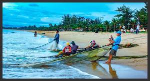 un grupo de personas en un barco en la playa en Minh Duc Hotel - Phan Rang en Phan Rang