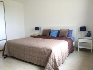 una camera da letto con un grande letto con cuscini blu di Casa Hermosa a Budoni