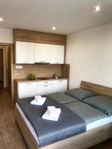 Apartment Poprad في بوبراد: غرفة نوم بسرير كبير وفوط بيضاء