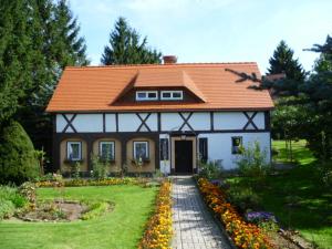 a house with an orange roof and a garden at Ferienwohnung Lange in Kurort Jonsdorf