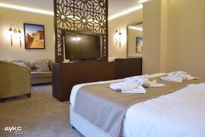a hotel room with a bed with towels on it at Sahara Hotel in Svilengrad