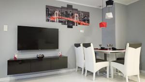 キェルツェにあるApartament Exclusive RedBlackのダイニングルーム(テレビ、テーブル、椅子付)