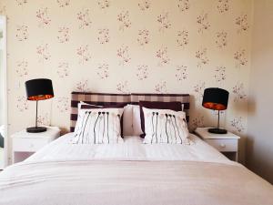 um quarto com uma cama com 2 candeeiros em mesas de cabeceira em Orles Barn Guest House em Ross on Wye