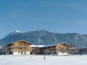 a person standing in the snow in front of a building at Chiemgau Appartements in Inzell