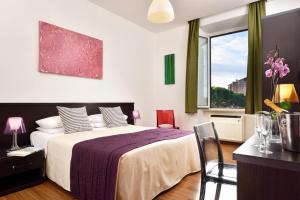 a bedroom with a bed and a table and a window at Colosseo Panorama in Rome