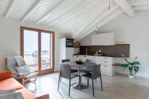 a kitchen and dining room with a table and chairs at Mansarda I Cipressi in Lenno
