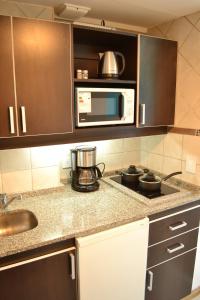 cocina con encimera y microondas en Nothofagus Apartments en San Carlos de Bariloche