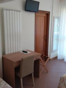 Zimmer mit einem Schreibtisch und einem TV an der Wand in der Unterkunft Albergo Nyers in Perugia