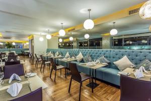a restaurant with a blue couch and tables and chairs at Apartamento seaway 935 Morros, La Boquilla in Cartagena de Indias