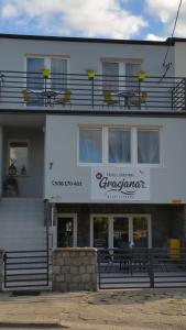 a white building with a sign for a restaurant at Pokoje Gościnne u Gracjana in Władysławowo