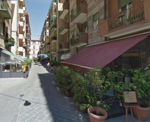 an empty street with plants in pots on a building at Interno 10 in La Spezia
