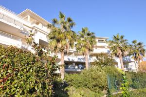 um edifício com palmeiras em frente em Elegant one-bedroom apartment with swimming pool - StayInAntibes - Le Vallon em Antibes