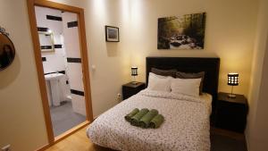 ein Schlafzimmer mit einem Bett und ein Badezimmer mit einem Spiegel in der Unterkunft Cozy Apartment In Center in Lissabon