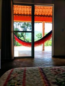una puerta abierta con una hamaca frente a un dormitorio en Praia do Jatobá en Sao Jorge