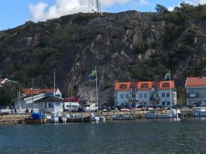 eine Gruppe von Booten, die in einem Hafen neben einem Berg angedockt sind in der Unterkunft Grebbestad in Grebbestad