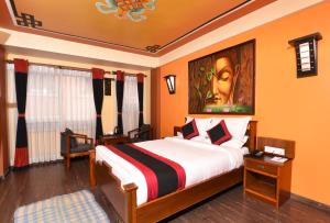 1 dormitorio con 1 cama y una pintura en la pared en Karma Boutique Hotel en Katmandú