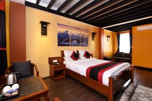 una camera da letto con un letto, una scrivania e una sedia di Karma Boutique Hotel a Kathmandu