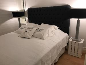 uma cama com lençóis brancos e almofadas em Grebbestad em Grebbestad