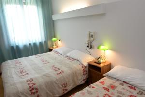 1 dormitorio con 2 camas junto a una ventana en Hotel Puntabella, en Varazze