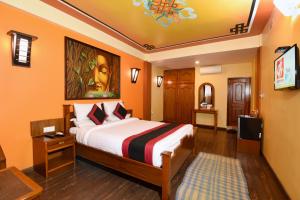 una camera d'albergo con un letto e una televisione di Karma Boutique Hotel a Kathmandu