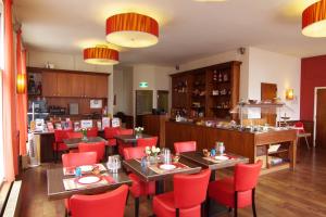فندق سيتي في أمستردام: مطعم فيه كراسي حمراء وطاولات في الغرفة