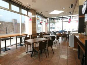 a restaurant with tables and chairs and windows at APA Hotel Kanazawa Chuo in Kanazawa