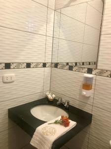 a bathroom with a sink with a towel and a drink at Los Alamos in Caraz
