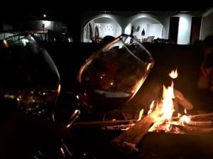two wine glasses sitting next to a fire at Los Alamos in Caraz