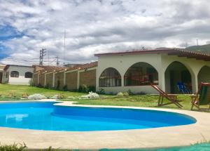 a house with a blue swimming pool in front of it at Los Alamos in Caraz