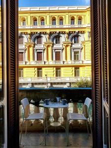 a table and chairs in front of a yellow building at Napoli Central Loft in Naples