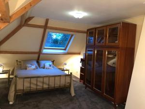 um quarto com uma cama e uma grande janela em Apartment in Romantic Villa em Bilthoven