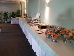 a long buffet line with bowls of food on it at Hotel Wyllandrie in Ootmarsum