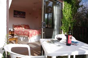 a white table with a bottle of wine on a patio at Skerries B and B in Lyme Regis