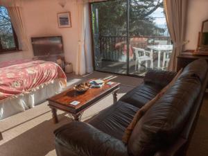 uma sala de estar com um sofá e uma mesa em Skerries B and B em Lyme Regis