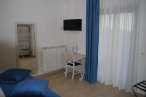 ロッカラーゾにあるHotel Il Bucaneveのリビングルーム(テーブル、青いカーテン付)