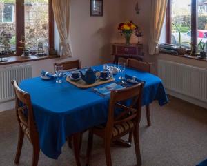 mesa de comedor con mantel azul en Skerries B and B, en Lyme Regis